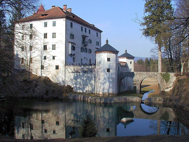 Grad Snežnik z belim pročeljem in grajskim parkom